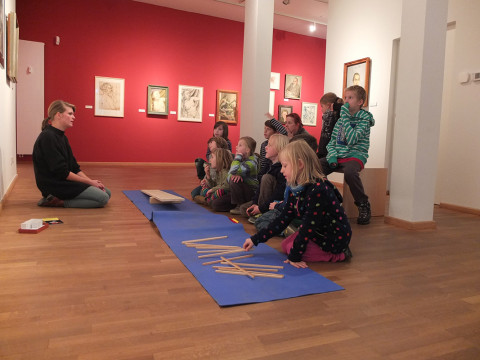 Schüler_innen beim Besuch des Stadtmuseums, während sie gerade das Arbeitsfeld der Museumspädagogin erklärt bekommen.