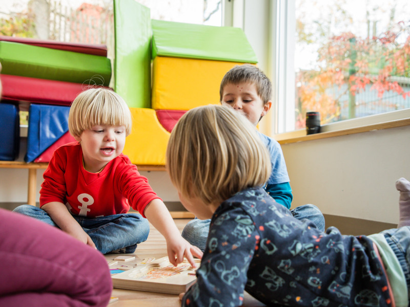 Knder spielen gemeinsam ein Holzspiel