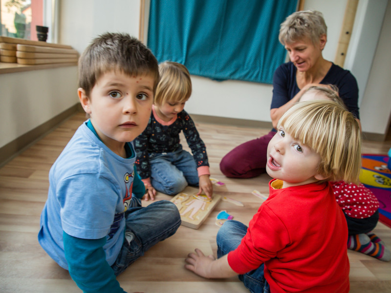 Kinder und Erzieherin spielen gemeinsam